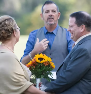Chip and Tami, a happy couple, celebrating with their wedding officiant John in Delaware.